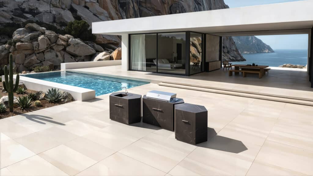 Dunkle Keramikoberfläche der modularen Outdoorküche bee outdoor vor moderner Villa mit Meerblick