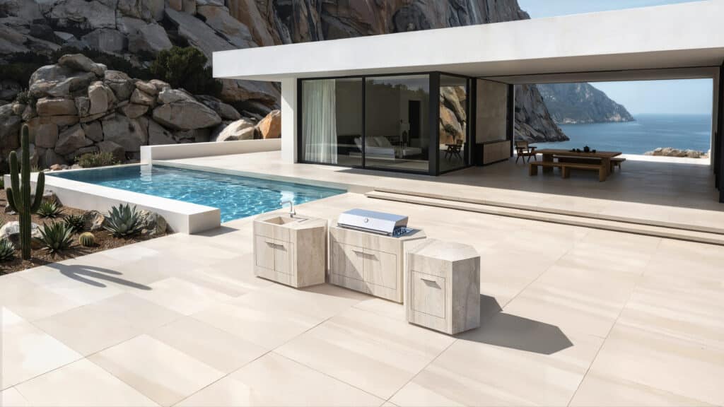 Helle, zeitlose Keramikoberfläche der modularen Outdoorküche bee outdoor vor luxuriöser Villa mit Meerblick
