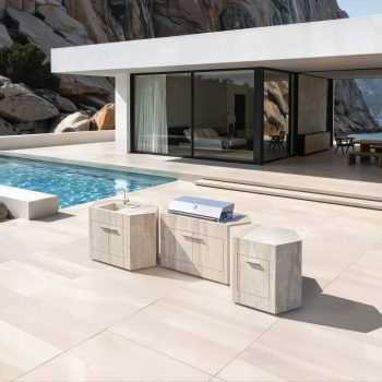 Helle, zeitlose Keramikoberfläche der modularen Outdoorküche bee outdoor vor luxuriöser Villa mit Meerblick