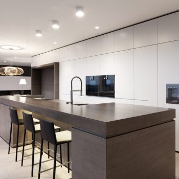 Offene Designküche mit Holz-Kochinsel und weißer Hochschrankzeile mit Gaggenau Geräten