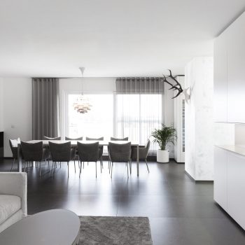 Offener Essbereich mit Tisch und Sesseln mit moderner offener Küche in Wien
